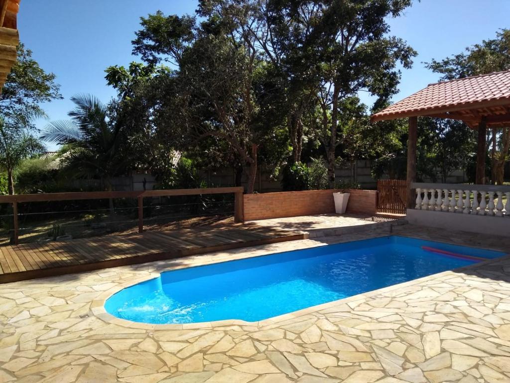 una piscina in un cortile con recinzione e alberi di Chacara Girassol a Botucatu