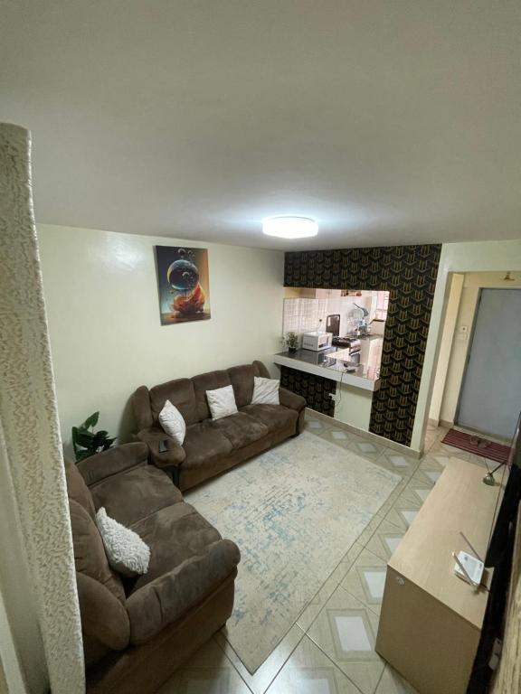 ein Wohnzimmer mit Couch und Küche in der Unterkunft Cozy Escape UTAWALA in Gatunga