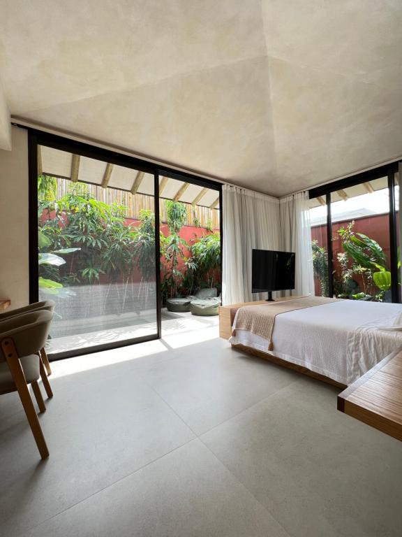 a bedroom with a large bed and large windows at Pousada Okas de Camburizinho in São Sebastião