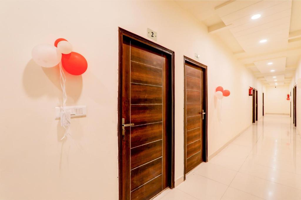 a hallway with a wooden door and balloons on the wall at Hotel O KAILASHA INN in Hasanganj