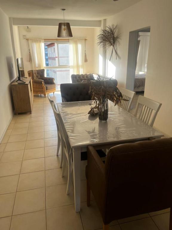 een woonkamer met een tafel met stoelen en een bank bij Metro in Villa Gesell