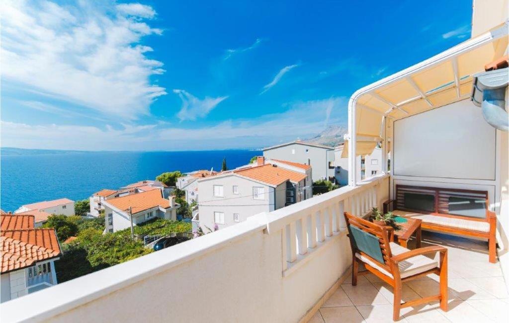 a balcony with a chair and a view of the ocean at Lovely Apartment In Omis With Wifi in Tice