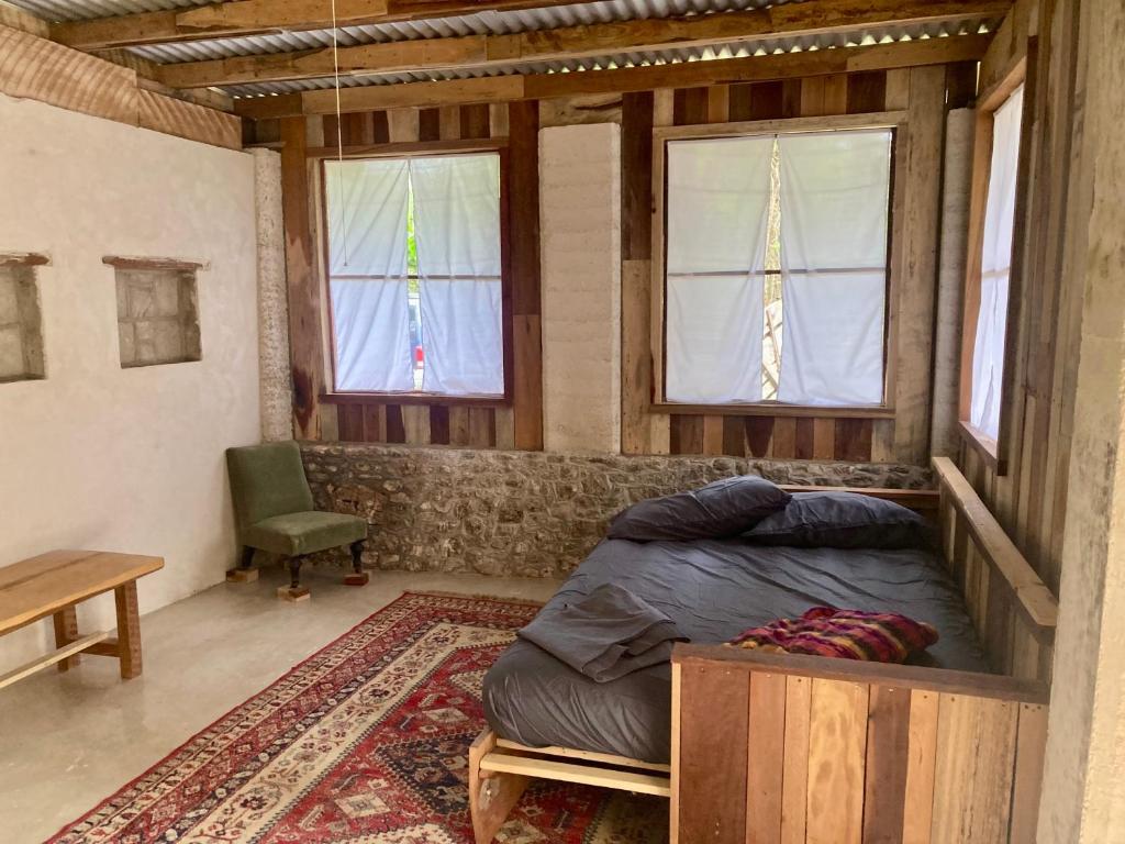 Un dormitorio con una cama en una habitación con ventanas. en 1888 North West Xaibe, en Corozal