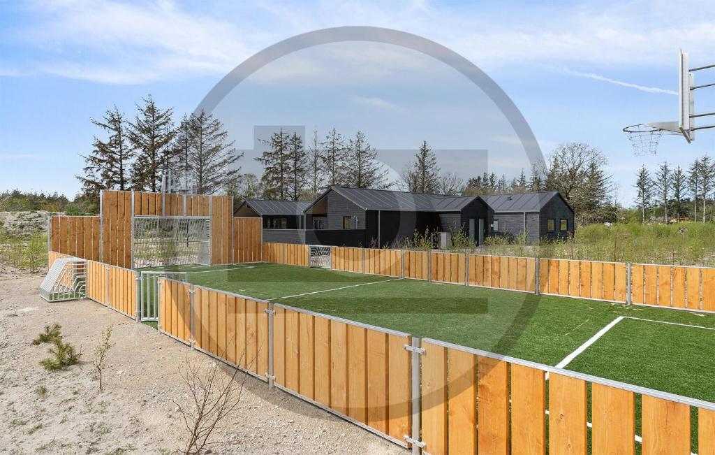 a house with a fence and a tennis court at Beautiful Home In Idestrup With Sauna in Stovby