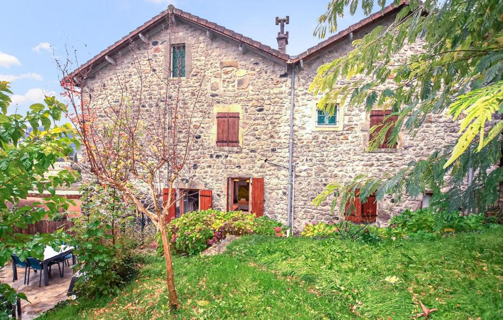 Lalevade-dʼArdècheにあるMaison En Pierresの木の前の古い石造家