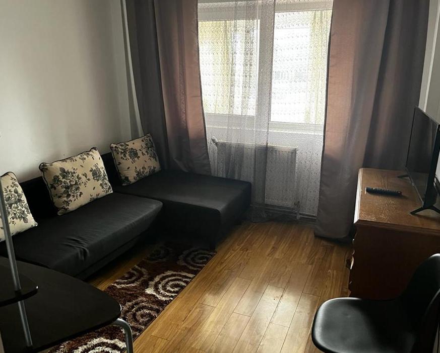 a living room with a couch and a window at Bros Apartment in Buzau