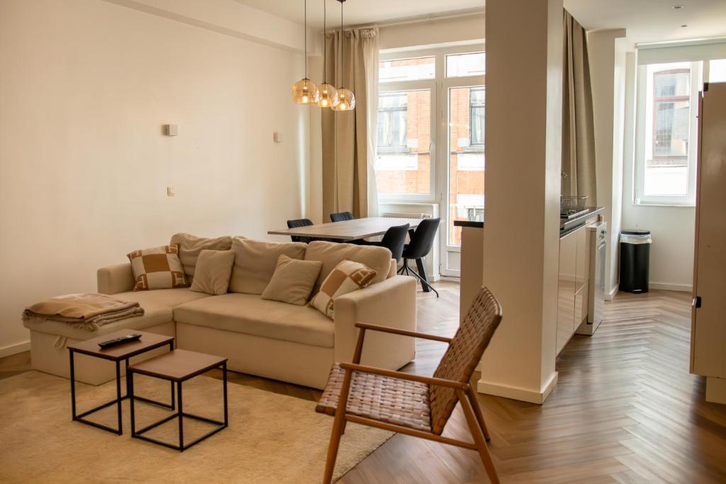 ein Wohnzimmer mit Sofa und Tisch in der Unterkunft Brussels South - Cosy Appartment in Brüssel