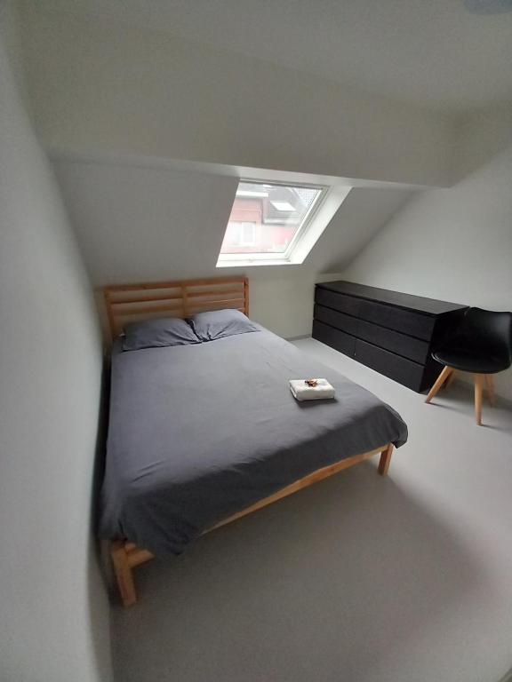 a small bedroom with a bed and a window at Chez Jean-Claude chambre pour 2 personnes in Wavre