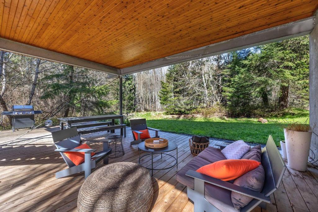a patio with a couch and chairs on a deck at Neal Creek Retreat in Mount Hood