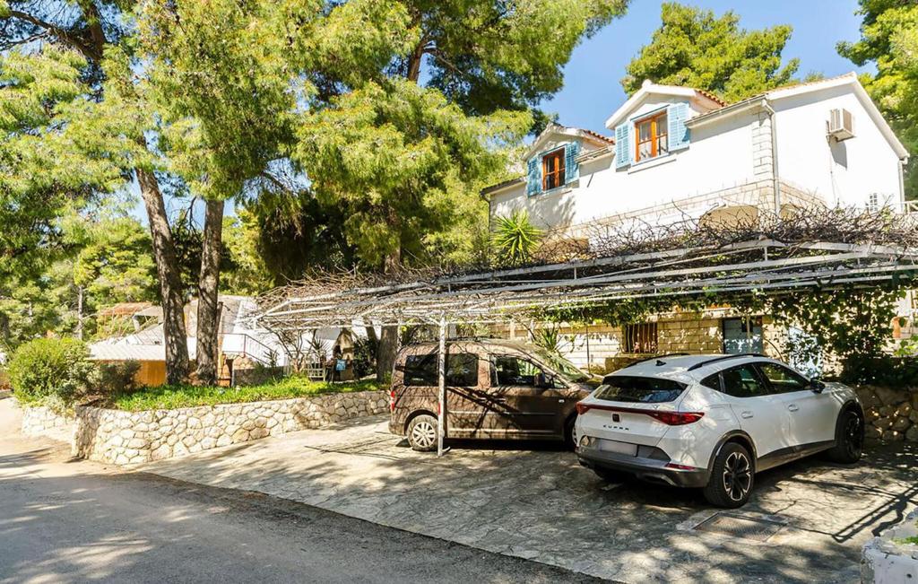 two cars parked in front of a house at Beautiful Apartment In Ivan Dolac With Wifi in Ivan Dolac