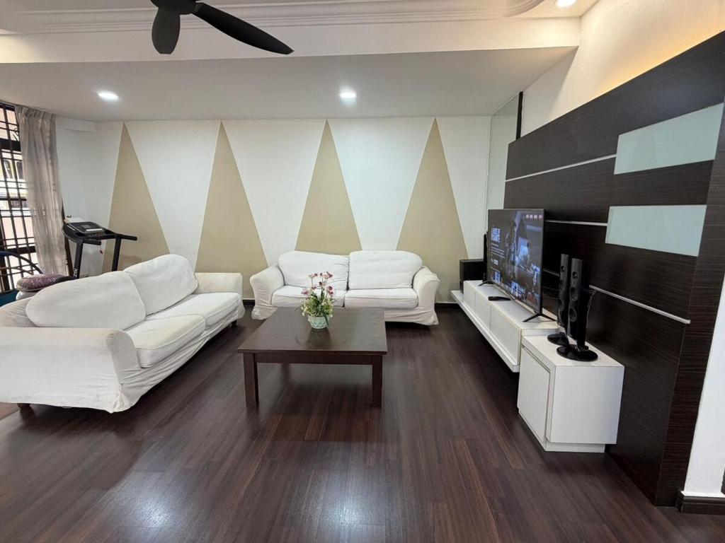 ein Wohnzimmer mit 2 weißen Sofas und einem TV in der Unterkunft Luxury 5Room 14pax Taman Desa Cermerlang in Ulu Tiram