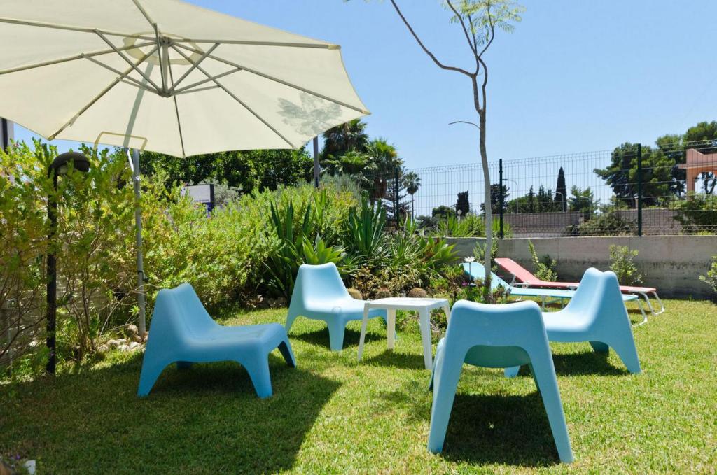 a group of chairs and a table and an umbrella at Villa Didi in Fontane Bianche