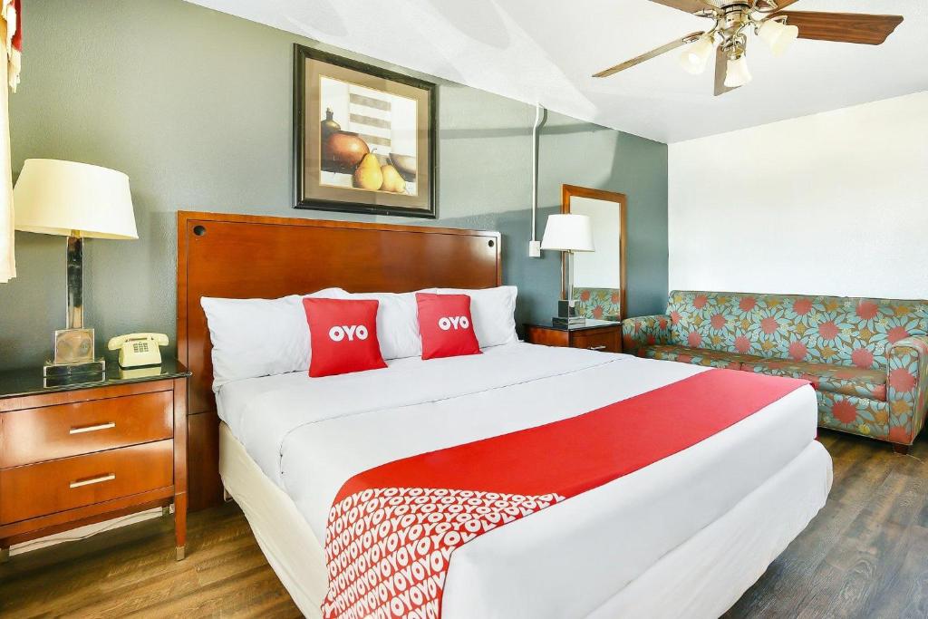 une chambre avec un grand lit avec des oreillers rouges dans l'établissement OYO Hotel McAlester OK S Main St, à McAlester