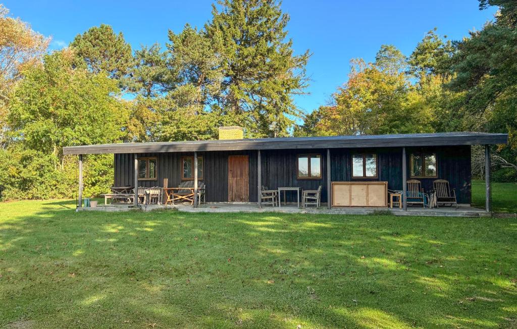 a house with chairs and tables in a yard at 2 Bedroom Stunning Home In Helsinge in Karsemose