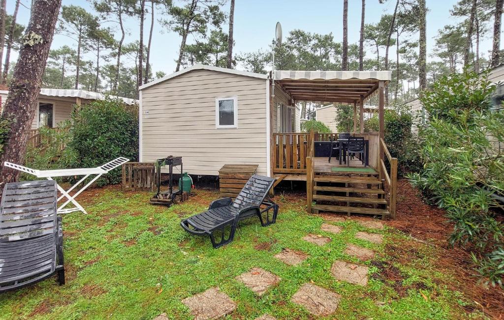 podwórko z szopą, dwoma krzesłami i huśtawką w obiekcie Stunning Stacaravan In Saint-Julien-En Born w mieście Saint-Julien-en-Born