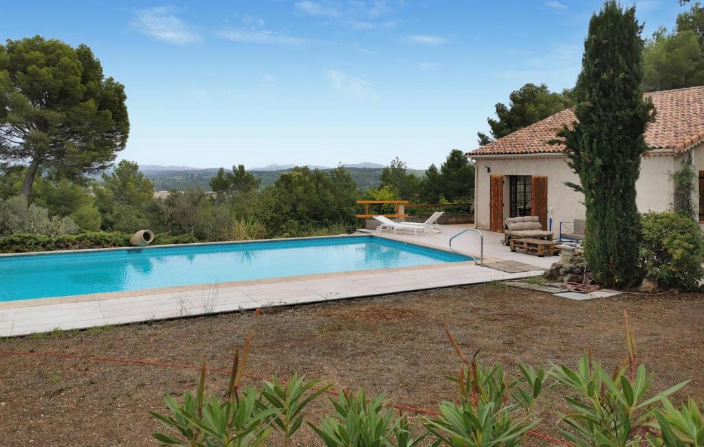 a swimming pool in front of a house at La Champêtre in Fayence