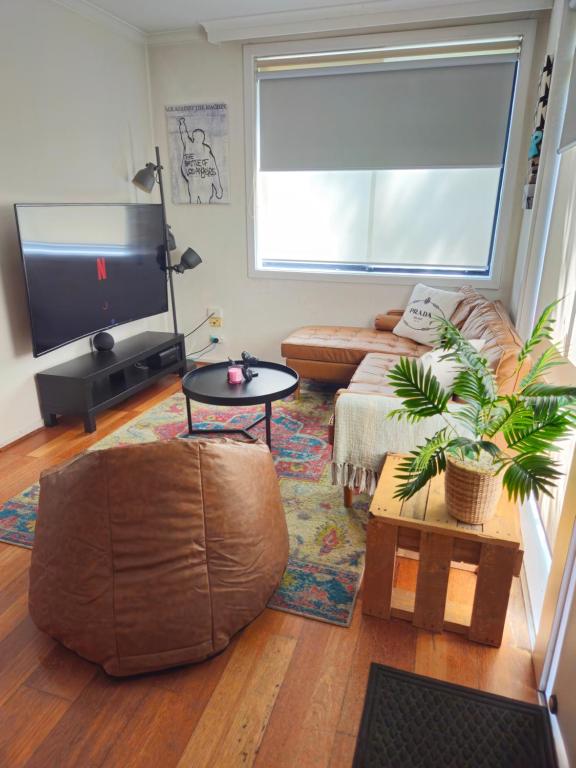 a living room with a couch and a flat screen tv at Quiet, Peaceful Northcote Unit in Melbourne