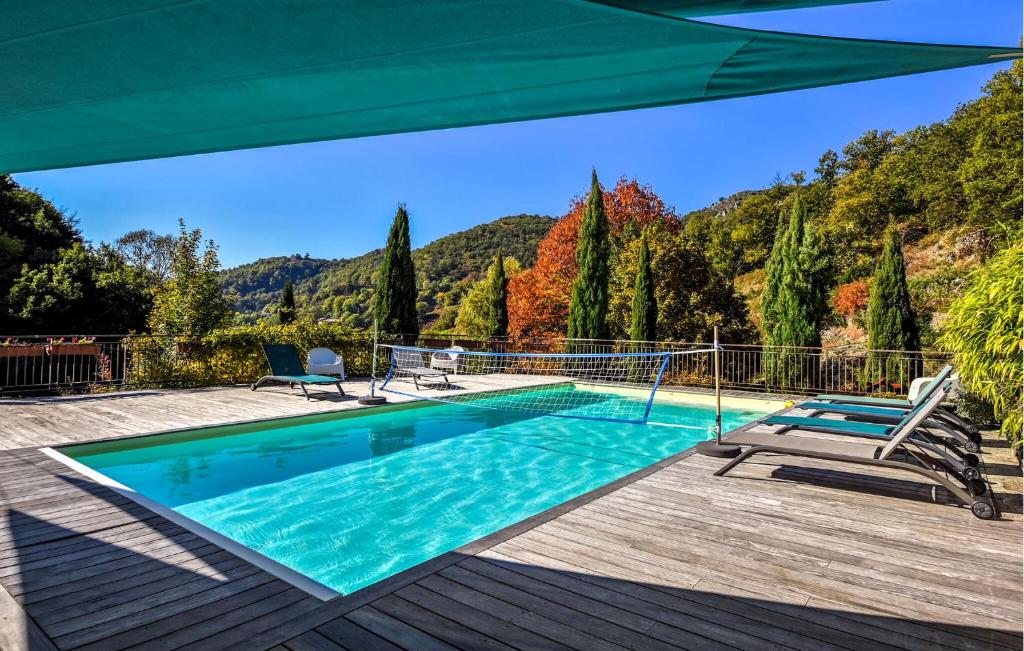 una piscina con sombrilla en una terraza de madera en Amazing Home In Genestelle, en Genestelle