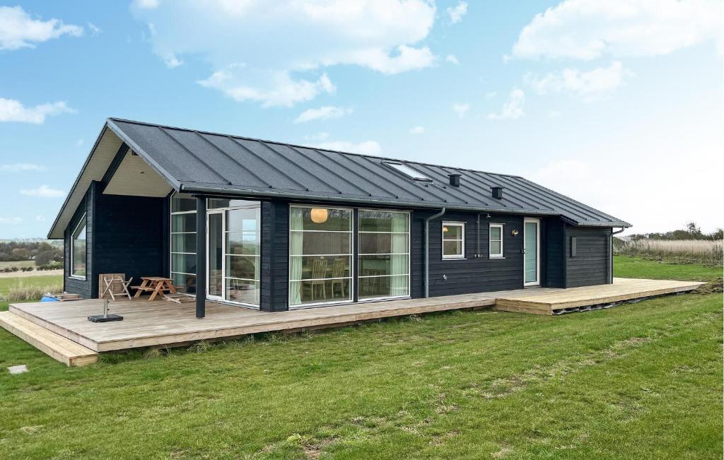 Una pequeña casa negra en una terraza en un campo en Awesome Home In Store Fuglede With Wifi, en Bjerge
