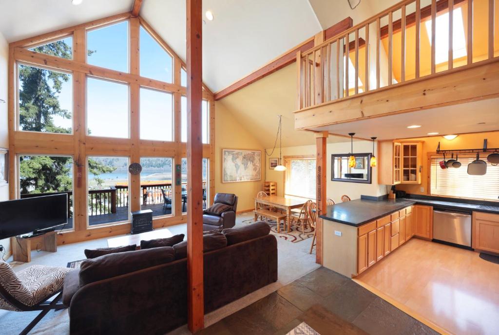 ein Wohnzimmer mit Couch und eine Küche mit Fenstern in der Unterkunft Sandbar Haven in Hood River