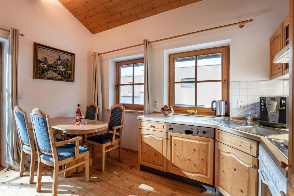 Hannes Appartement in im Zentrum von Kirchberg - by NV-Appartements في كيرشبرغ ان تيرول: مطبخ مع طاولة وطاولة وكراسي