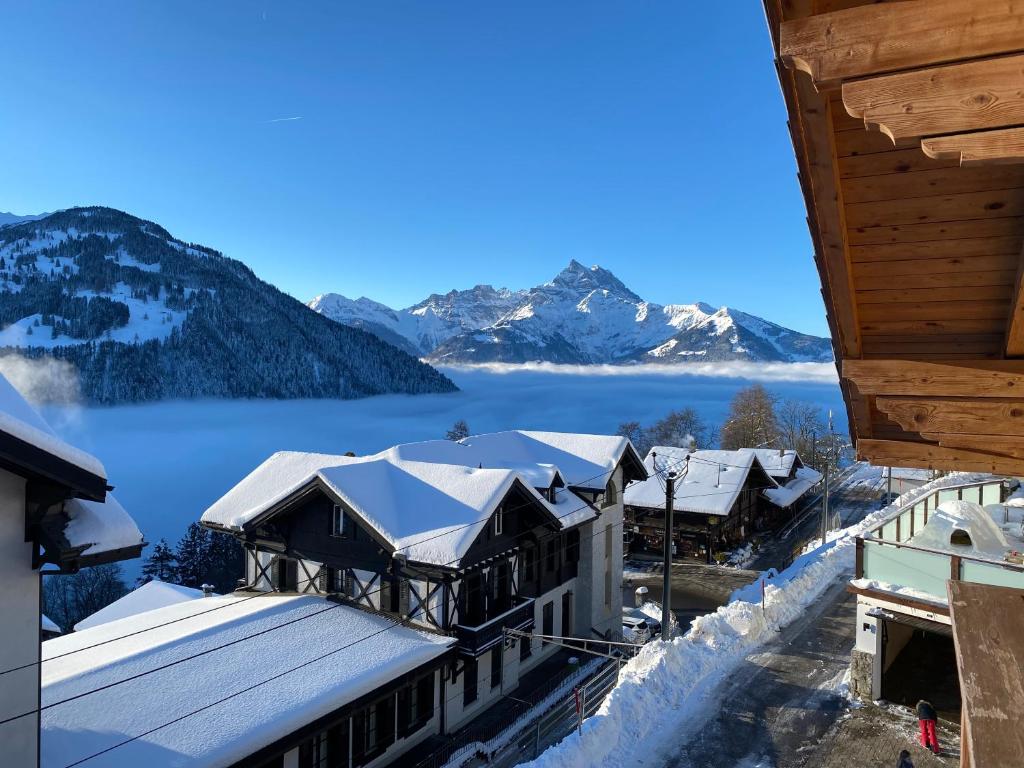 a view of a resort with snow covered mountains at Chalet L'Adret, 3,5 pièces dans les combles. in Gryon