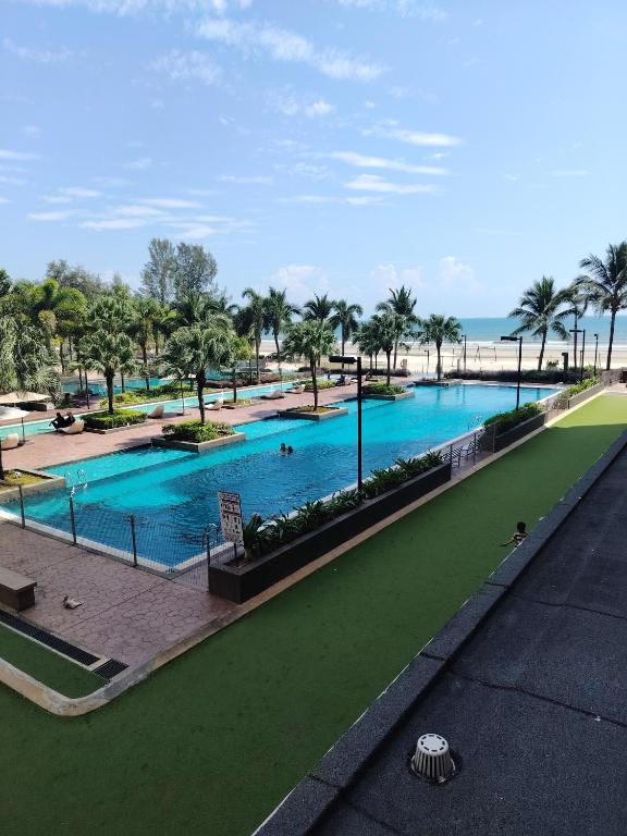 a view of a pool with palm trees and the ocean at Timurbay Seafront By Moonlight pool view in Kuantan
