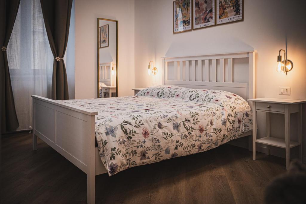 a bedroom with a bed with a floral bedspread at Casamè Apartment Sulmona - a due passi da centro, free bike park in Sulmona