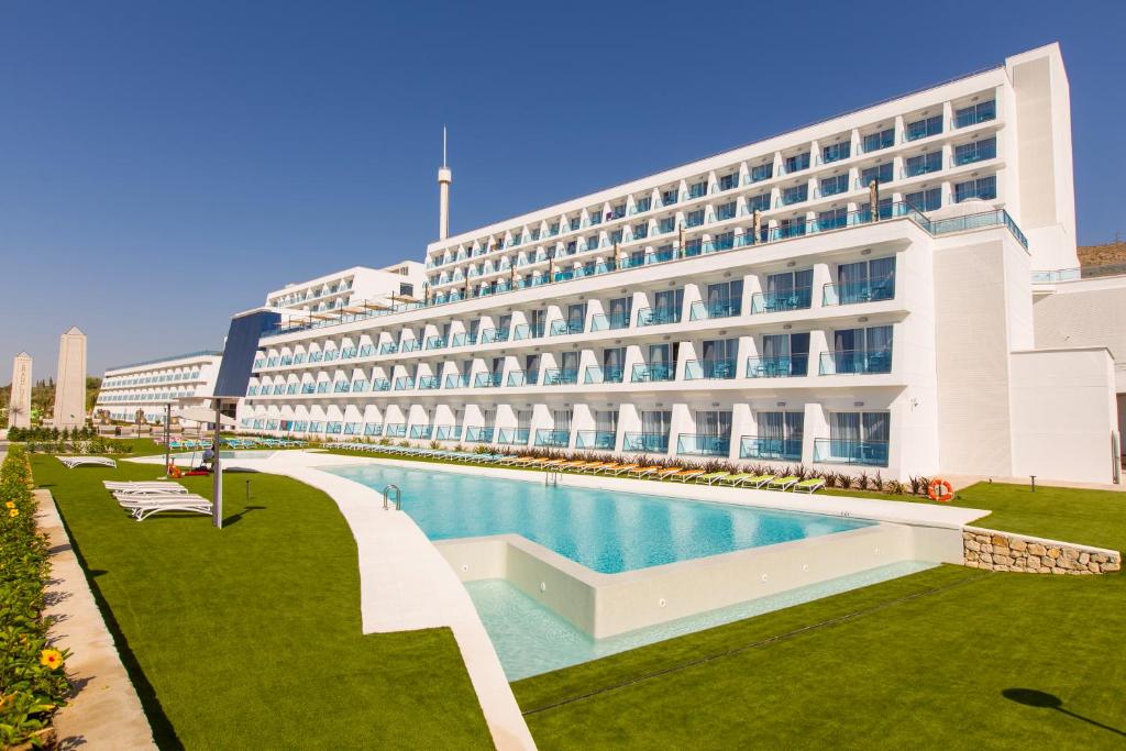 un hotel con piscina di fronte a un edificio di Grand Luxor Hotel a Benidorm