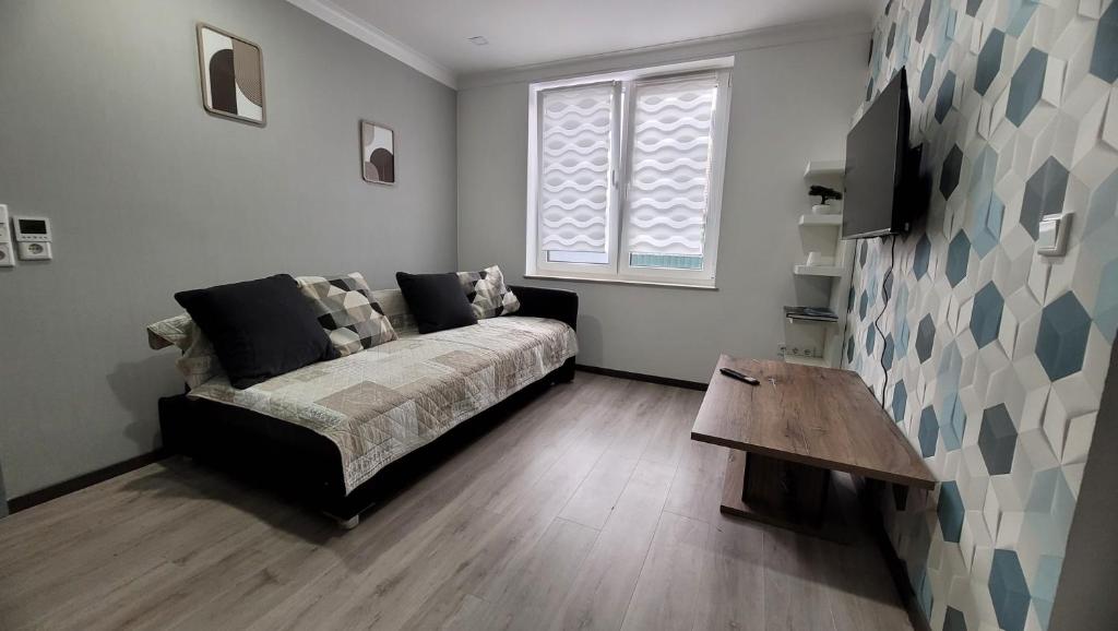 a bedroom with a bed and a table and a window at Ferienwohnung Nordstern in Papenburg