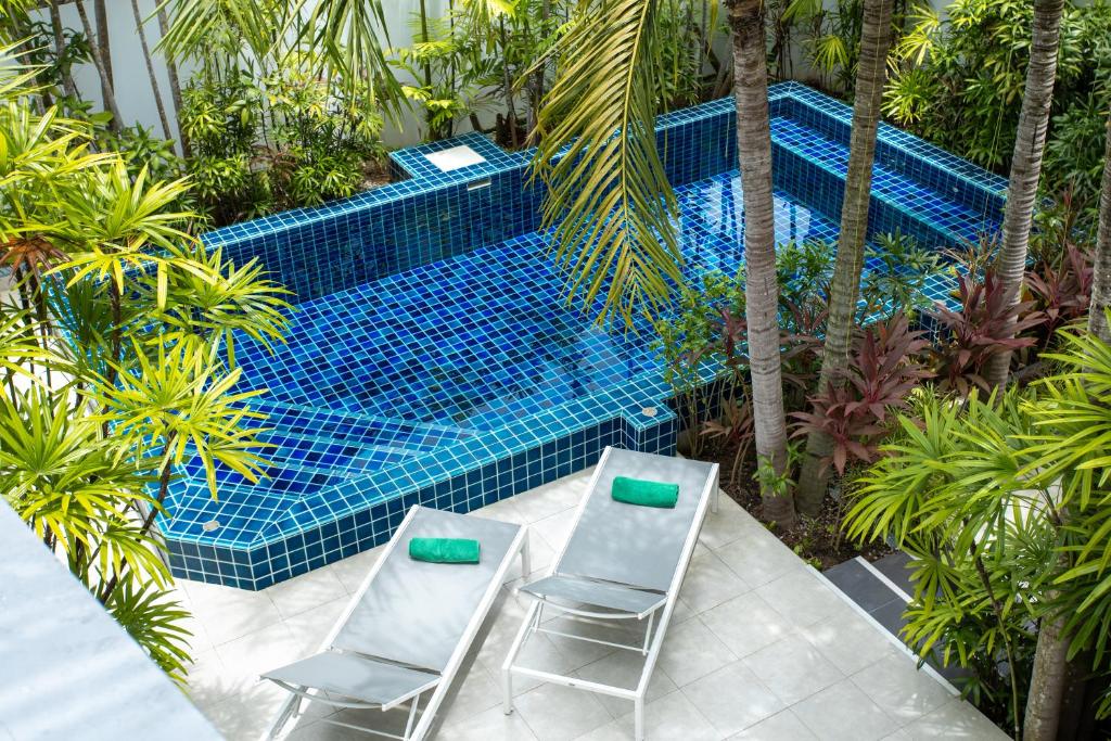 two chairs sitting next to a swimming pool at Villa Guenlaur 3 studios with kitchenette and pool in Ban Saiyuan (1)
