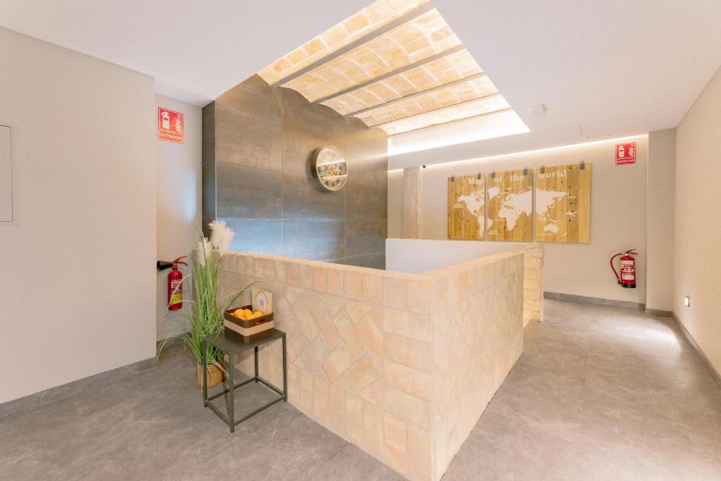 una habitación con una pared de ladrillo con una pintura en la pared en Guastavino by Alma Suites, en Valencia