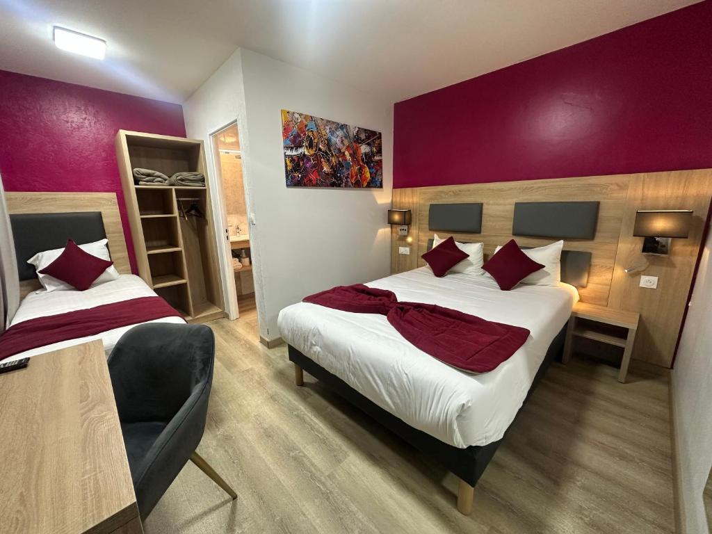 a bedroom with two beds and a purple wall at Hôtel NOROTEL in Brumath