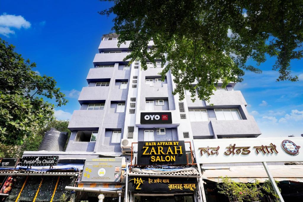 un edificio blanco alto con señales delante en Hotel O Siba Inn, en Bombay