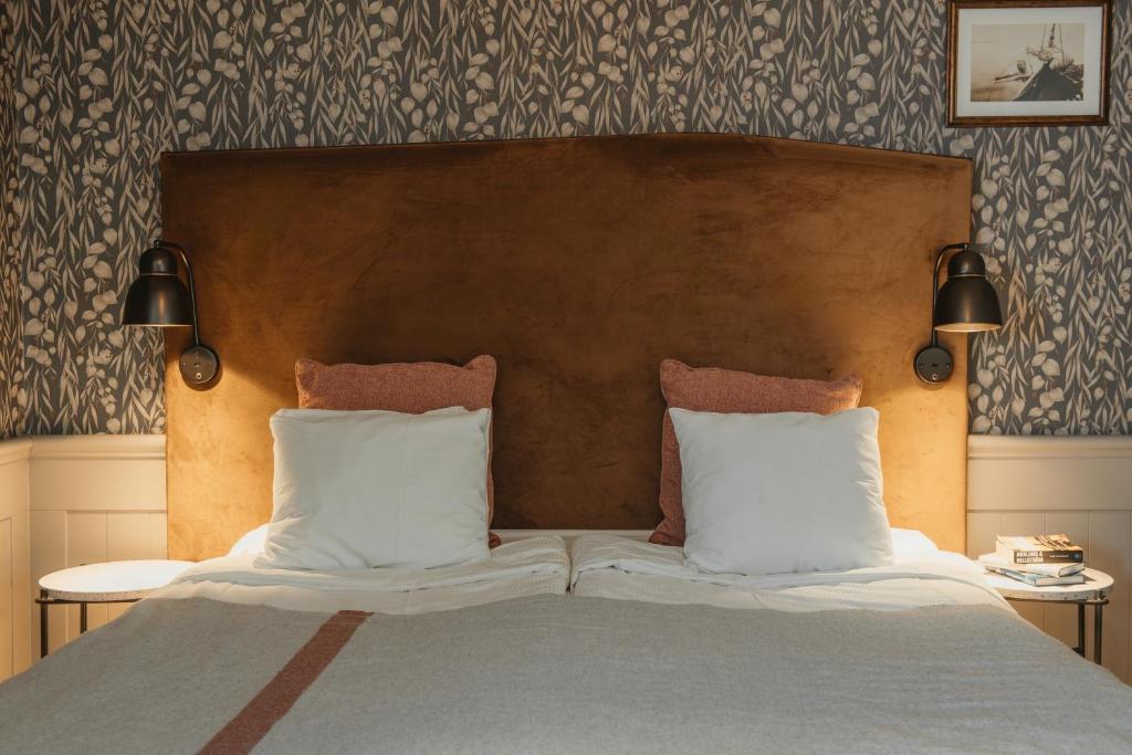 a bedroom with a bed with two pillows at Home Hotel Fregatten in Varberg