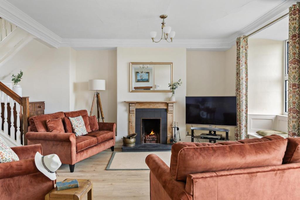 a living room filled with furniture and a fireplace at Rose Cottage in Port Isaac