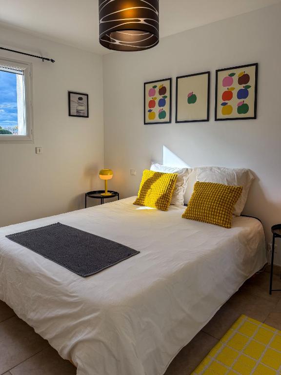a bedroom with a large white bed with yellow pillows at Ti ponch in Mont-de-Marsan