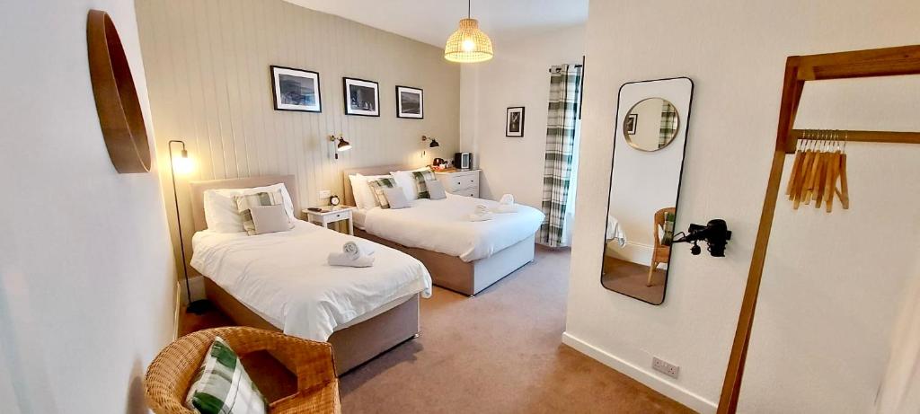 a room with two beds and a mirror at Glenthorne Guest House in Tenby