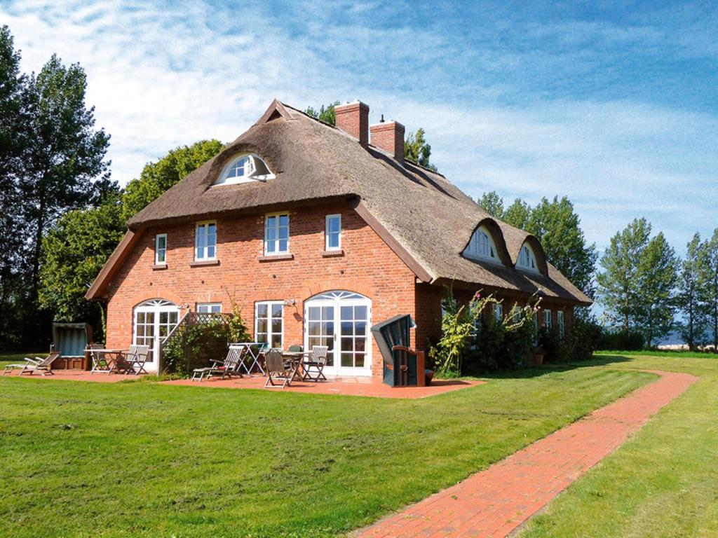a large brick house with a gambrel roof at Ferienwohnung "Wildgans" in Schaprode