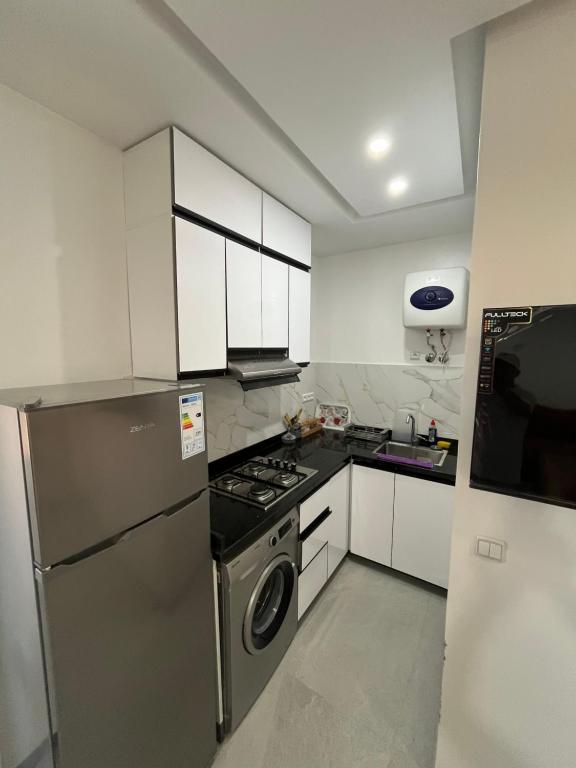 a kitchen with a stainless steel refrigerator and white cabinets at Atlantic view Tamraght 1 in Tamraght Oufella