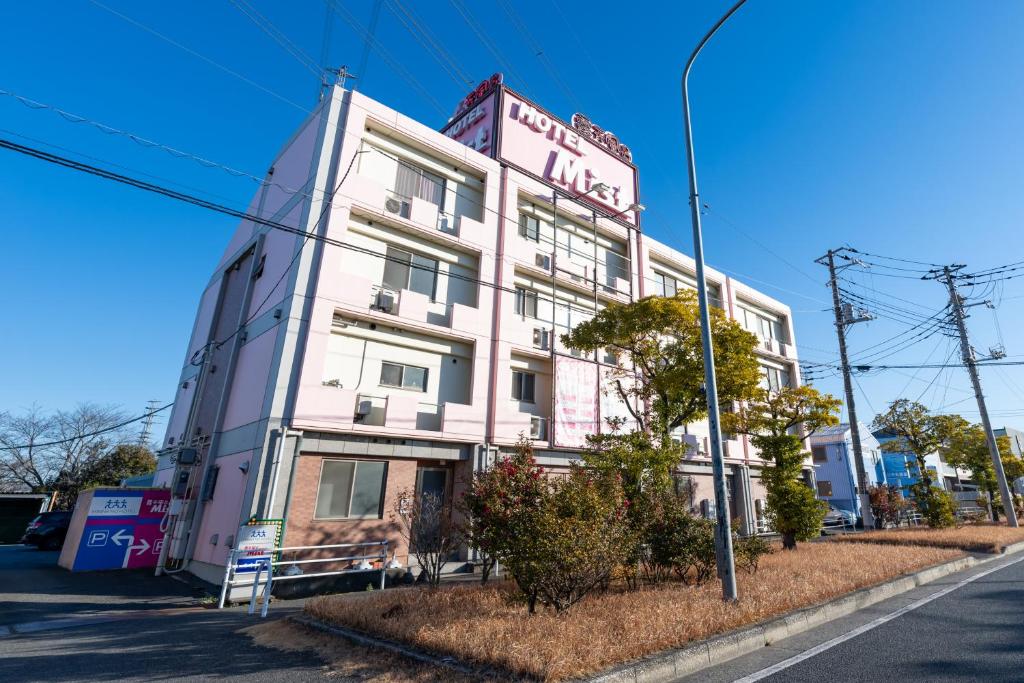 a pink building with a sign on it on a street at Hotel Mist -Adult Only-CHIBA in Chiba