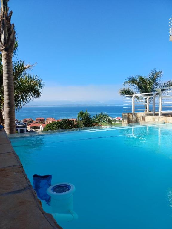 a swimming pool with the ocean in the background at Eagle's Nest in Mossel Bay