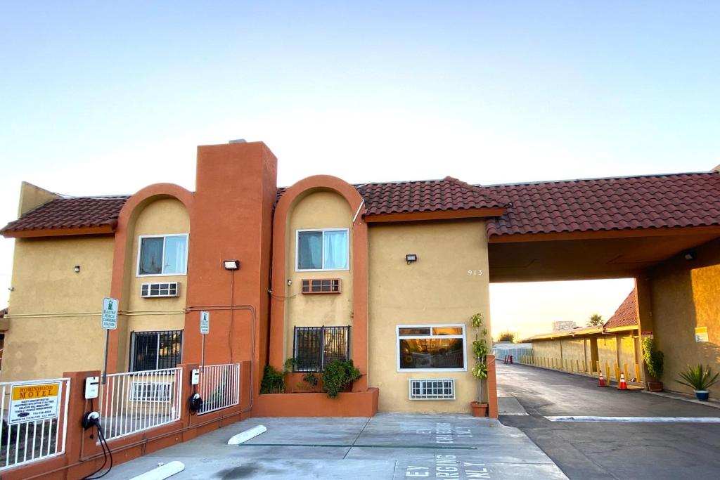 a building with a parking lot in front of it at Robinhood Motel Anaheim West in Anaheim