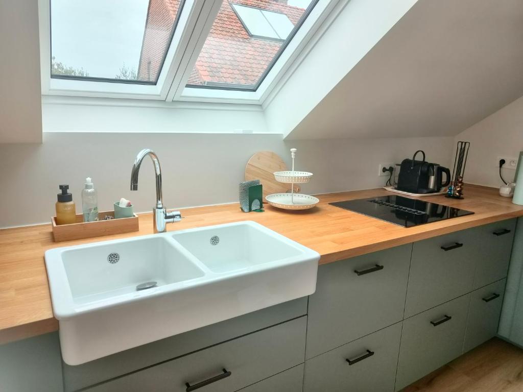 a kitchen with a white sink and a window at Vakantiewoning De Woestijn - Den Ast in Roosdaal