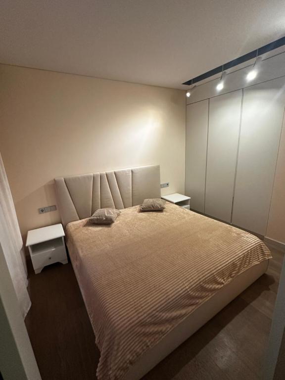 a bedroom with a bed with two pillows on it at Stilingas dviejų kambarių butas in Vilnius