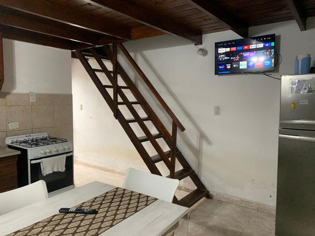 a kitchen with a staircase leading to a kitchen with a tv at Disfrutá tu estadía en Romana Dolores a solo 10 cuadras del parque termal Conseguí un ahorro exclusivo para el parque in Dolores