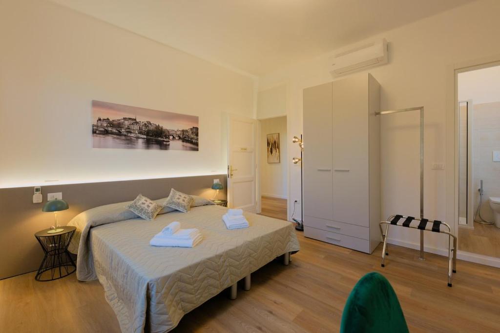 a bedroom with a bed with two towels on it at Camera Helsinki - La Casa di Carta Affittacamere in Udine