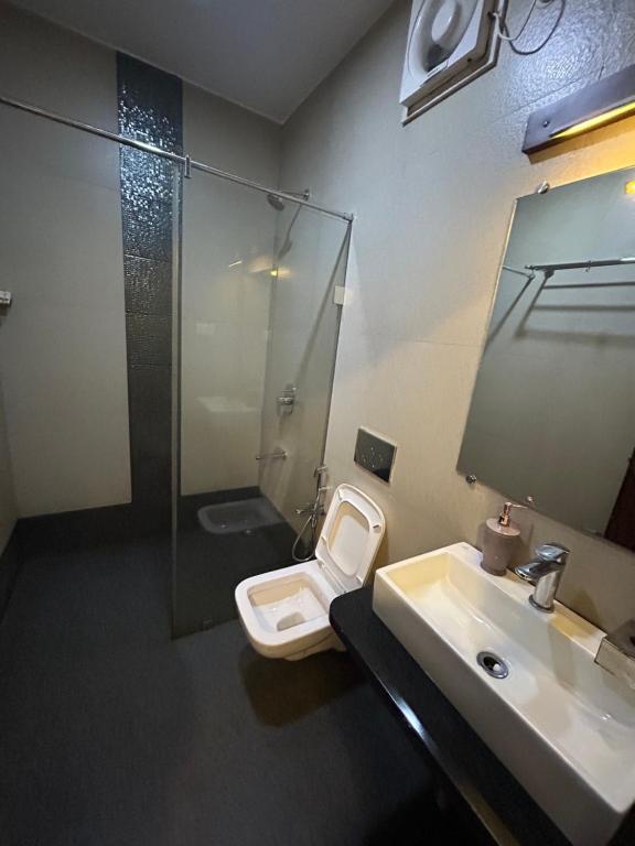 a bathroom with a toilet and a sink and a shower at Casa goa in Calangute
