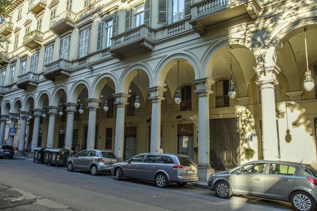 una fila de autos estacionados frente a un edificio en Hotel Torino Porta Susa en Turín