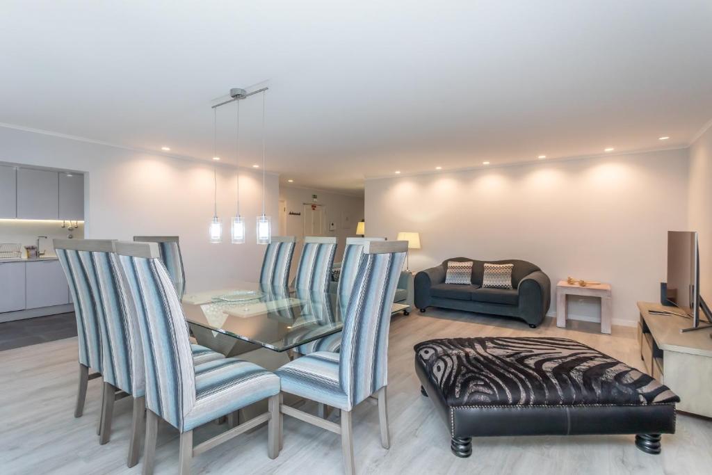 ein Wohnzimmer mit Tisch und Stühlen in der Unterkunft BeGuest Jardim Quinta da Alagoa Luxury Stay in Carcavelos